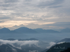 A ringside photo of the sun coming up from behind the Garhwal Himalayas. Several peaks are visible, along with a beautiful valley nestling between the hills. Prints available.