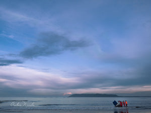 A group of lifeguards struggle to tow a boat into the ocean. Set against the backdrop of a spectacular pre-dawn sky, and the blue ocean, this beautiful photograph captures the story of human effort succinctly.  Grab a print now!
